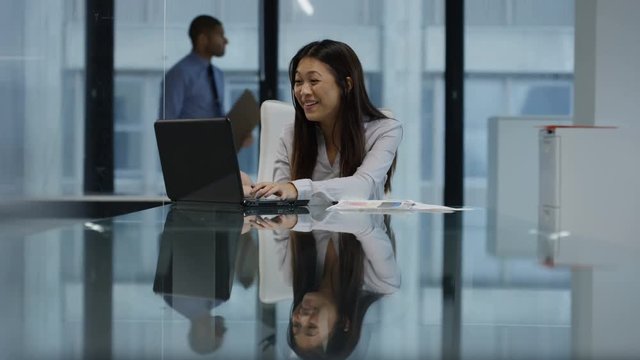  Businesswoman working on laptop sees something which makes her very happy