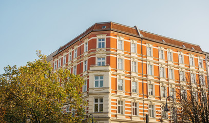 orange corner building with green tree