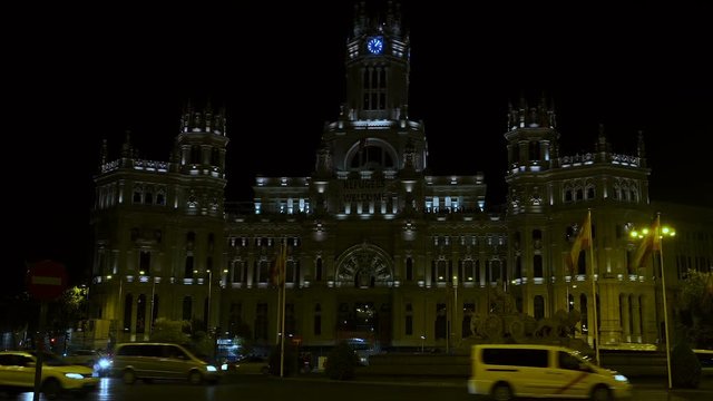Madrid, Spain City Hall Cybele Palace, Palacio de Cibeles night view.
Traffic before the Communications Palace at Cibeles Square with banner mentioning "Refugees Welcome".