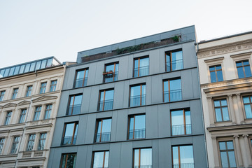 Fototapeta na wymiar futuristic facade next to historical apartment houses