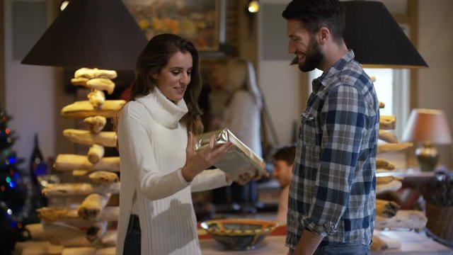  Happy couple at Xmas, man giving his partner a gift