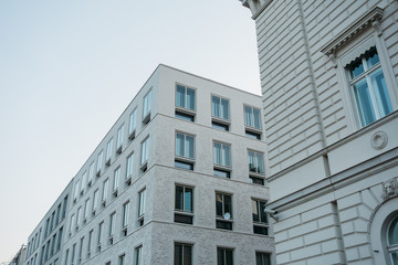 modern white apartment building next to an older residential one