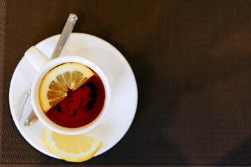 cup of tea with lemon on a brown background