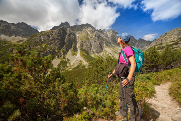 Fototapeta na wymiar Hiking woman admiring the beauty of rocky mountains