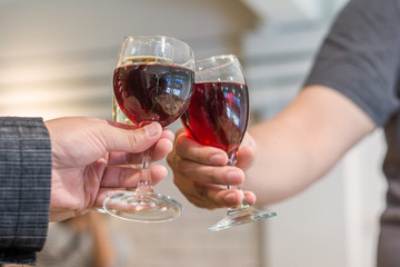 Man and friend celebrating success with red wine.