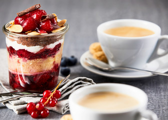 Layered dessert in jar with cup of coffee