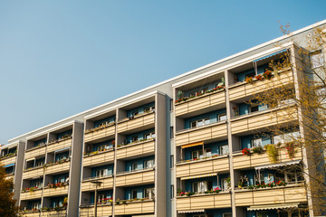 grey plattenbau building with yellow balcony
