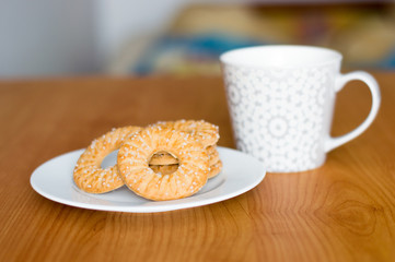 Rings cookies with sugar on white plate.