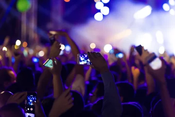Deurstickers Hand with a smartphone records live music festival © ververidis