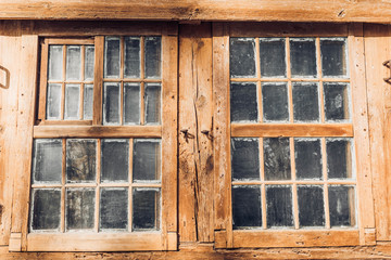 Front view of the windows in an old wooden house. Facade of an ancient timbered house