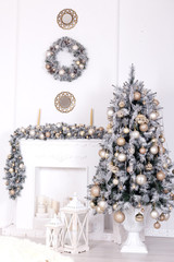Christmas tree with christmas balls near decoreted fireplace.