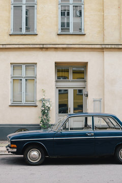 Old car parked in front of house wall