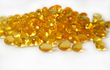 Omega-3 fish fat oil capsules close up on a white background.