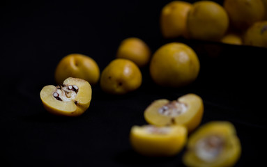 Ripped yellow fruits of quince (Chaenomeles) on dark background table