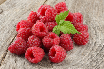 ripe raspberries with green leaf on old wooden table