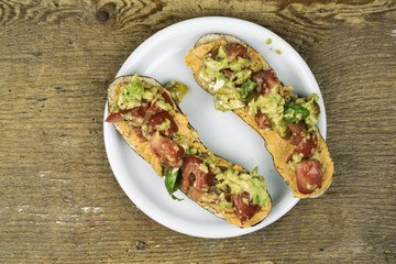 Close-up high-angle view of a tasty homemade snack on a white plate on a rustic wooden table