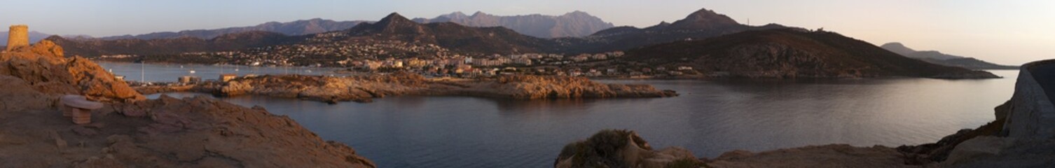 Fototapeta na wymiar Corsica, 30/08/2017: lo skyline di Isola Rossa, famosa città dell'Alta Corsica, con vista al tramonto della torre genovese costruita nel XV secolo in cima all'Isola della Pietra