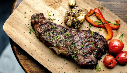 Grilled steak on wooden plate