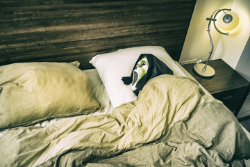 Grunge Halloween scary scene/Zombie entity tucked in the bed with open mouth and black hood waiting...