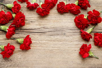 Red carnations on wooden background