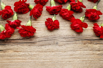 Red carnations on wooden background