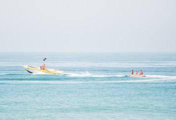 People riding on banana boat in the sea.