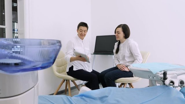 Dentist showing client the x-ray on his tablet in the dental office