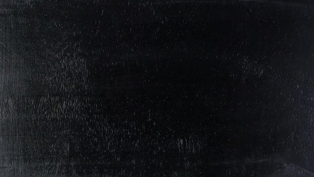 Stop motion animation of hand drawing countdown numbers on black chalkboard. 4k movie timelapse