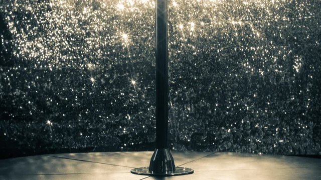 a pole in a club or pole dance studio with a sparkling background