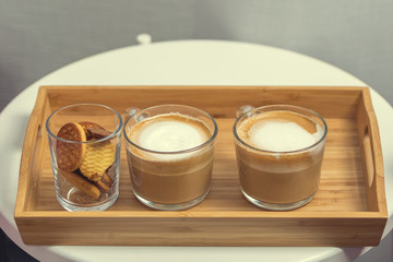 Two cups of coffee with milk on a tray