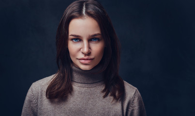 A woman dressed in a long neck brown jacket.