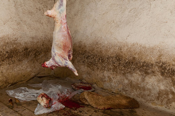 In a village killed a ram on a holiday the farmer removes the skin from the ram. Fresh carcass of...