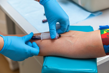 the doctor collects blood in a syringe, Nurse takes blood from the veins on the arm