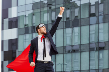 A superhero businessman is raising his hand up against a busines