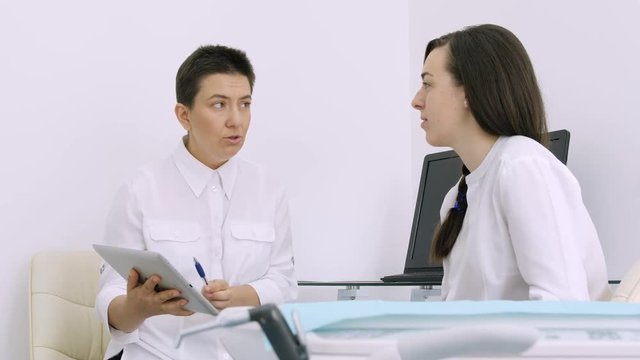 Dentist showing client the x-ray on his tablet in the dental office
