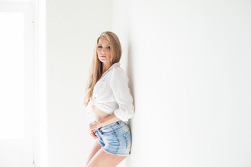 Fototapeta na wymiar beautiful blonde girl with blue eyes posing on a white background