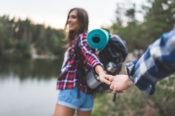 woman guiding boyfriend to wild lake