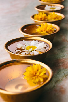 Flowers floating on water on small recipients in Buddhism temple
