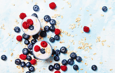 Naklejka na ściany i meble Sweet berry dessert with oatmeal, yogurt, blueberries and raspberries, top view