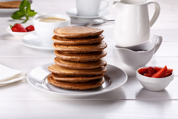 Stack of chocolate pancakes with strawberries.