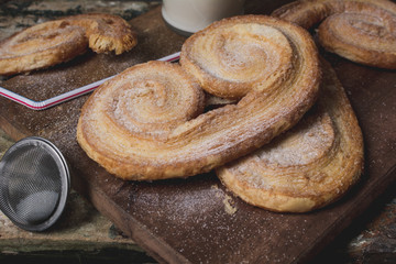 Sweet baking in powdered sugar on a wooden board, shallow depth of cuts