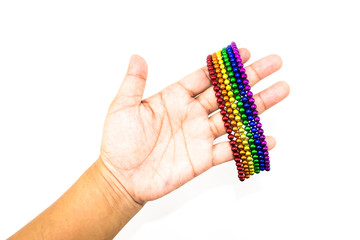 Womand hand holding a colorful spheres magnet bracelet