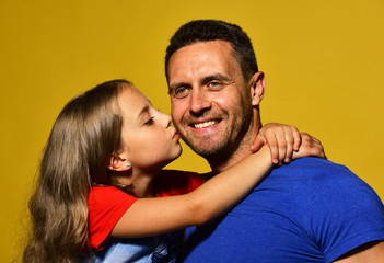 Fototapeta premium Daughter kisses her daddy in cheek. Child and father hug