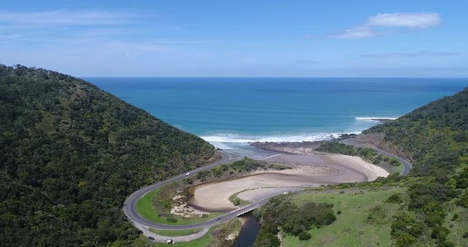 George river near Lorne on Great Ocean road hill range coast with a loop of a road following the coastline in aerial shoot.
