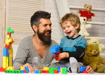 Boy and man play together. Dad and kid with toys