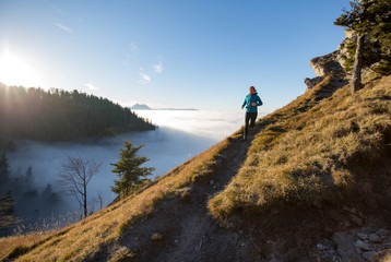 A young woman does mountain running or a trail run at the beautiful Nockstein mountain in Salzburg, Austria.