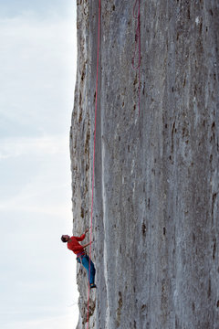 A mountain climber is hanging on the wall of the one of the Barmsteine rock towers, which are part of the Hassel Mountains in the Bavarian Alps between Austria and Germany.