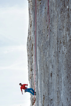 A mountain climber is hanging on the wall of the one of the Barmsteine rock towers, which are part of the Hassel Mountains in the Bavarian Alps between Austria and Germany.