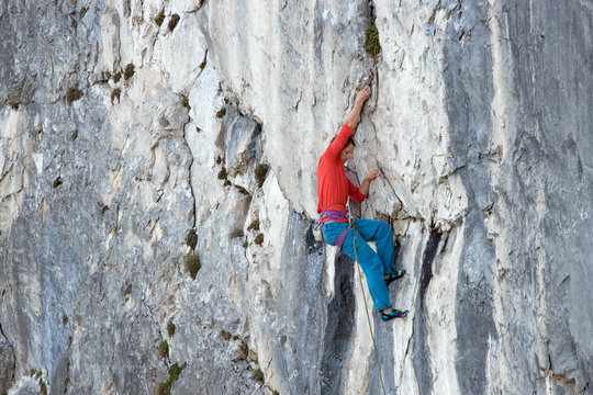 A mountain climber is hanging on the wall of the one of the Barmsteine rock towers, which are part of the Hassel Mountains in the Bavarian Alps between Austria and Germany.