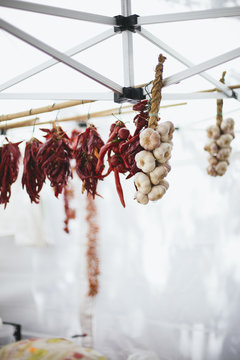 Dried garlic and red peppers hung at farmers market stand in Italy